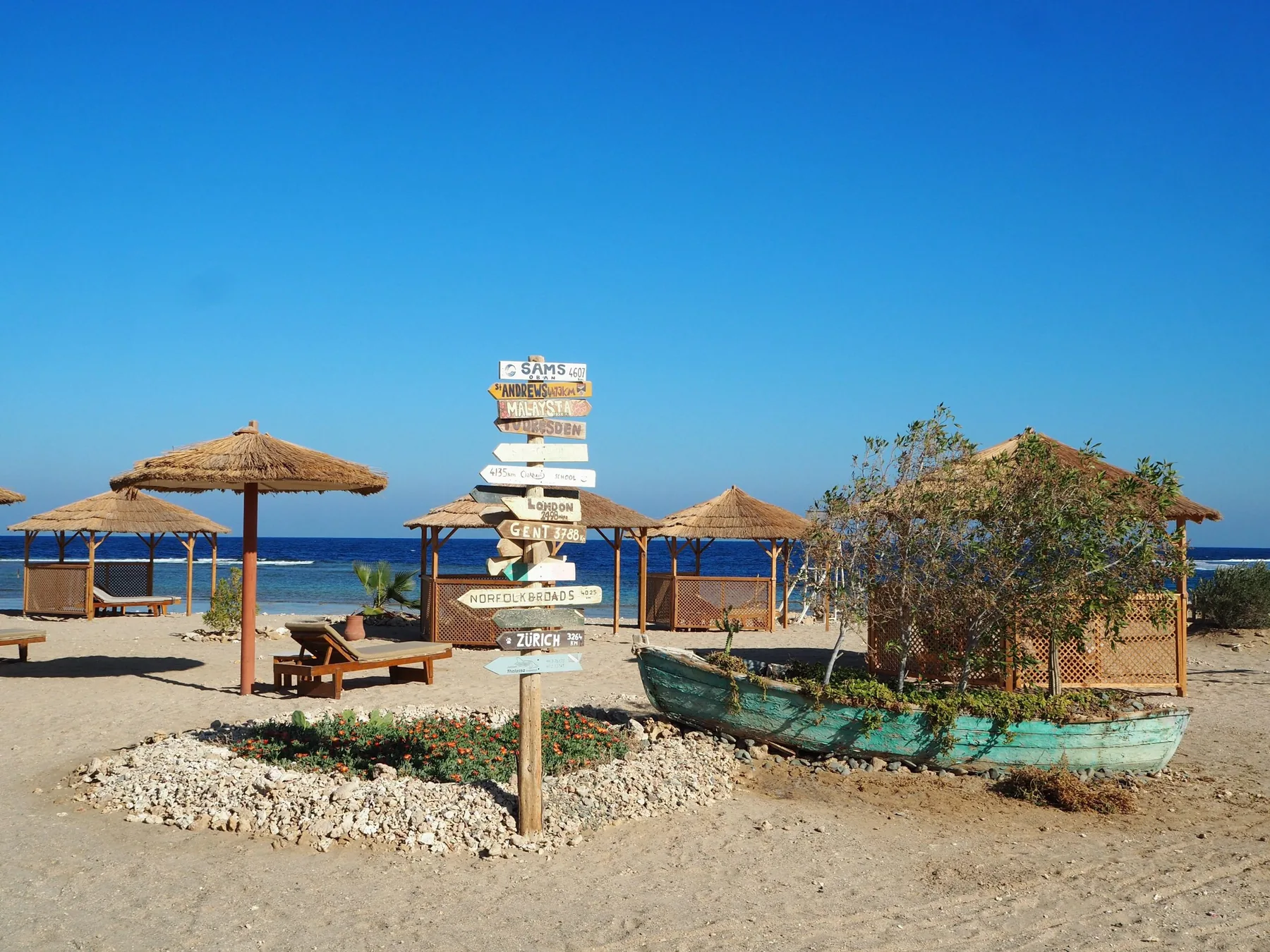 Private beach at Roots Red Sea with shaded cabanas and the sea